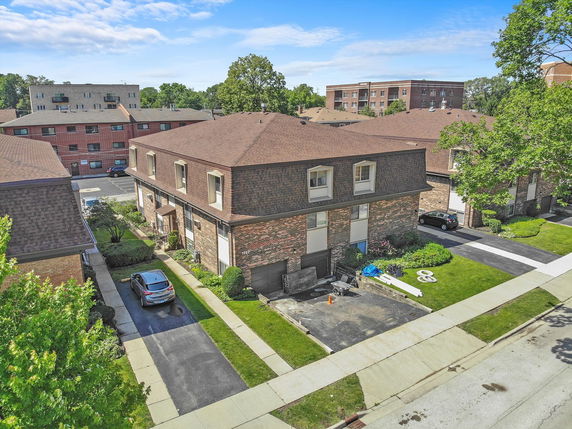 Front view of a two-story residential building with a driveway.
