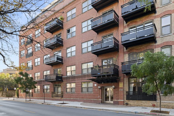 Front view of a multi-story apartment building with balconies.