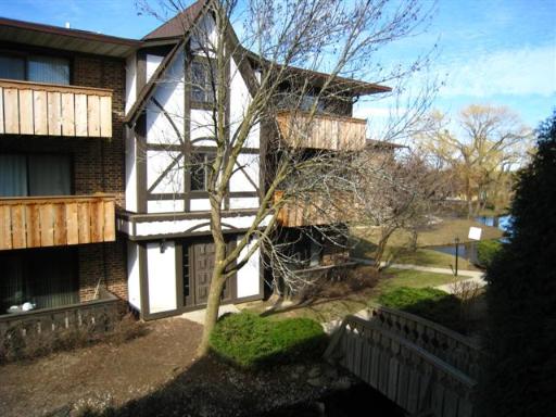 Front view of a multi-story building with wooden balconies and a sloped roof.