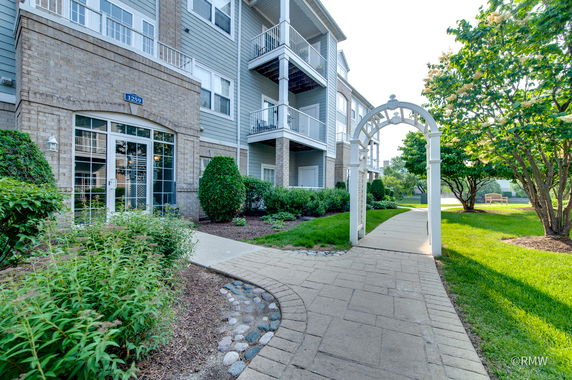 Front view of a multi-story residential building with balconies and a brick exterior.