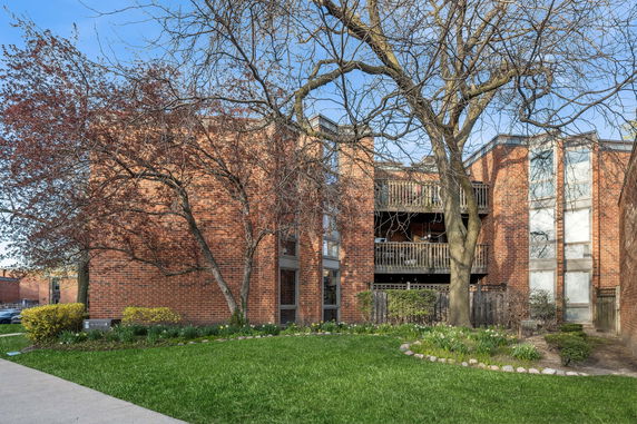 Front view of a multi-story brick building with balconies.