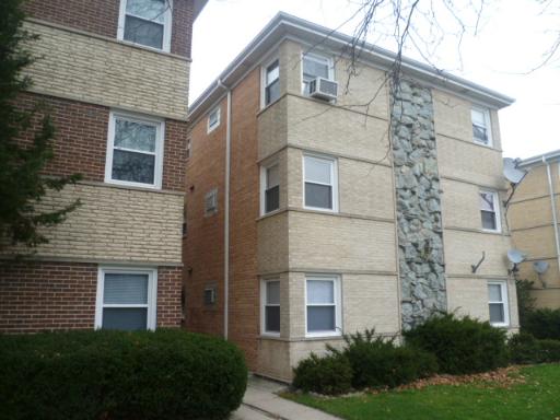 Front view of a multi-story residential building with brick and stone exterior.