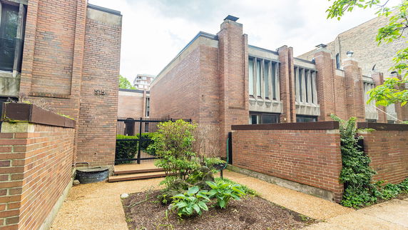 Front view of a brick building with large windows and architectural detailing.
