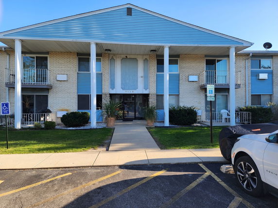Front view of a two-story building with columns and balconies.