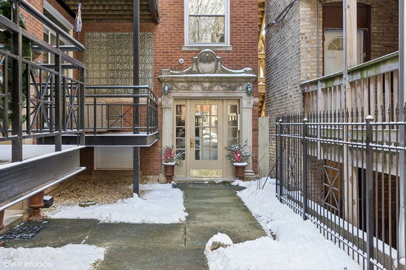 Front view of a building entrance with decorative door and railing.