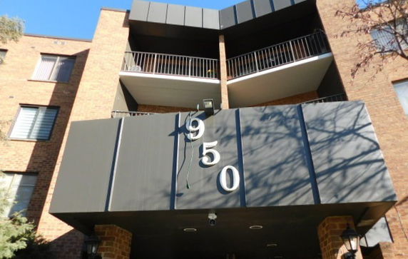 Front view of a multi-story building with balconies and building number 950 displayed.