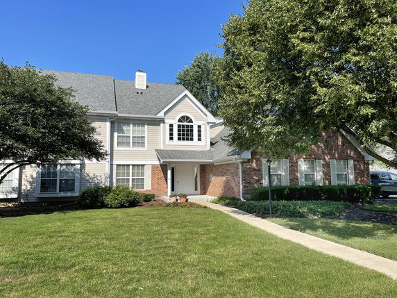 Front view of a two-story house with brick and siding exterior.