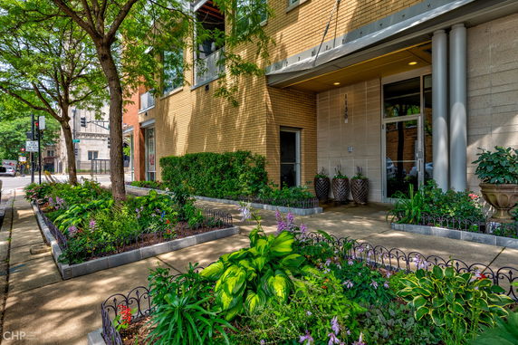 Front view of a building with a brick exterior and landscaped garden.
