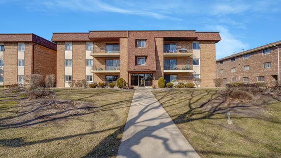 Front view of a multi-story brick building with balconies.