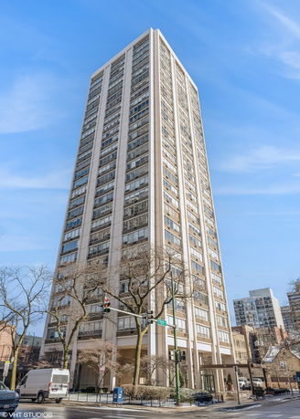 Front view of a tall, multi-story apartment building in an urban setting.
