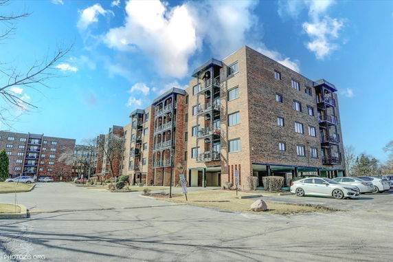 Front view of multi-story brick apartment buildings with balconies.