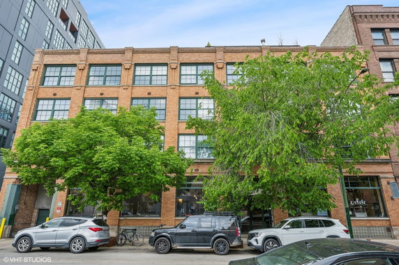 Front view of a brick multi-story commercial building with large windows.