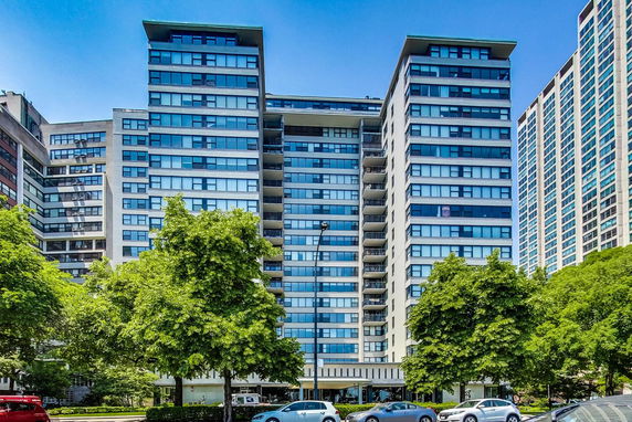 Front view of a multi-story residential building with balconies and large windows.
