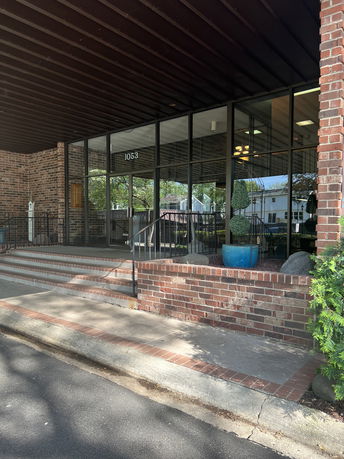 Front view of a building with glass windows and brick walls.