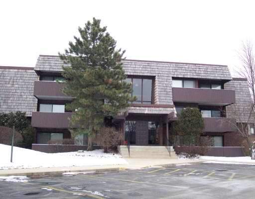 Front view of a multi-story building with a distinctive roof design and large windows.