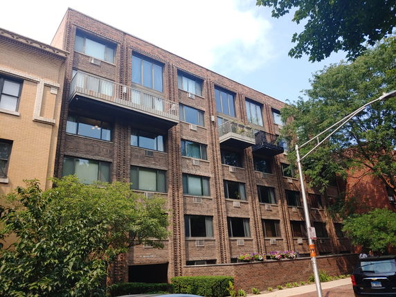 Front view of a multi-story apartment building with balconies.
