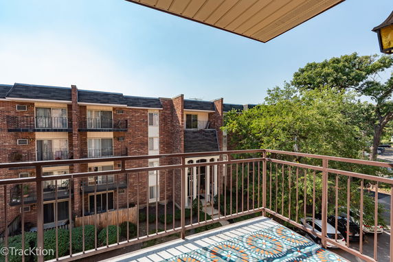 View of nearby residential buildings and trees from a balcony.
