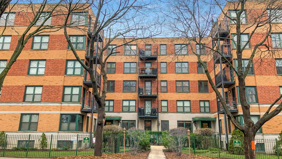 Front view of a multi-story apartment building with balconies.