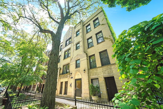 Front view of a multi-story apartment building with beige brickwork.