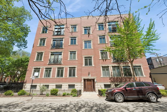 Front view of a four-story brick building with multiple windows.