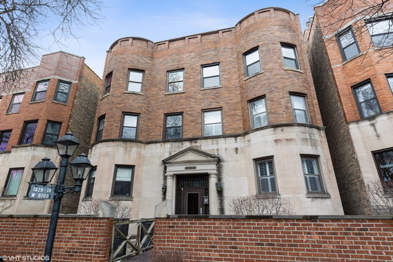 Front view of a multi-story brick building with arched windows.