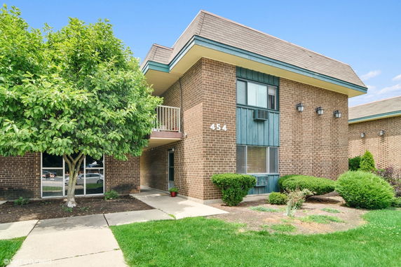 Front view of a two-story brick building with a balcony.