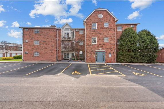 Front view of a brick apartment building with multiple floors.