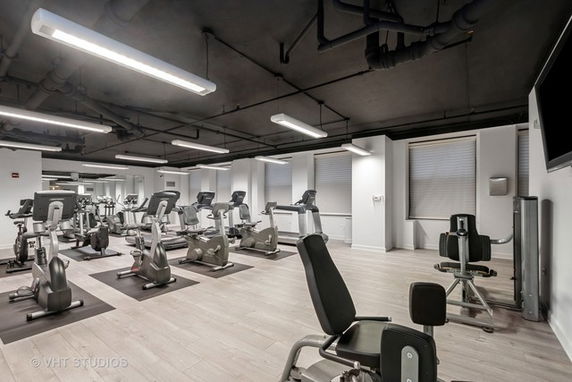 Indoor gym area with exercise equipment and machines.