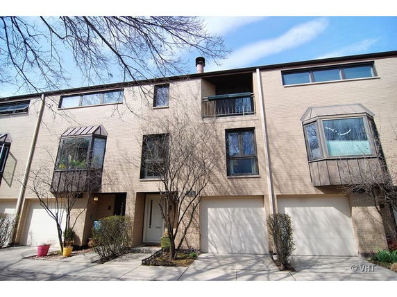 Front view of a multi-story townhouse with garages.