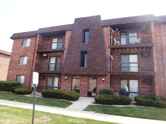 Front view of a three-story brick apartment building.