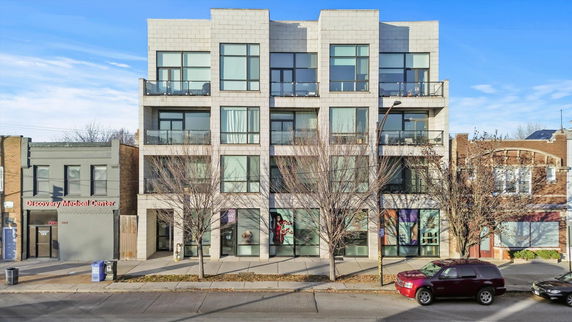 Front view of a modern multi-story building with large windows.