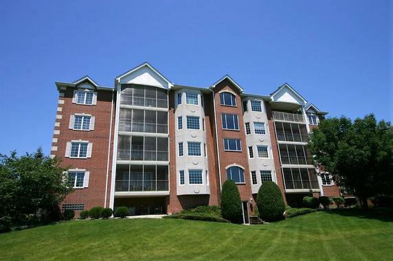Front view of a multi-story apartment building with a red brick facade.