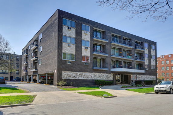 Front view of a multi-story apartment building with balconies.