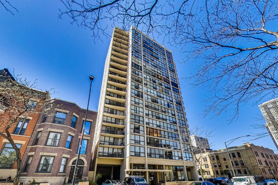 Front view of a multi-story apartment building with a modern glass facade.