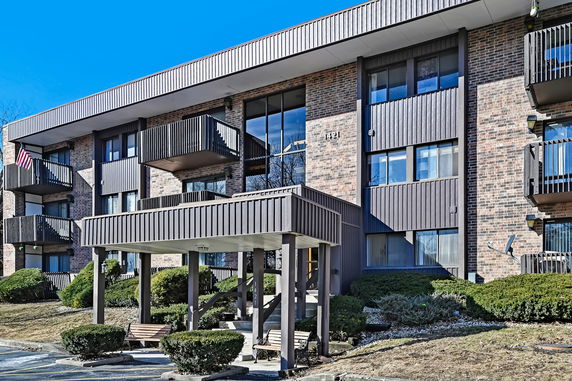 Front view of a three-story apartment building with balconies.