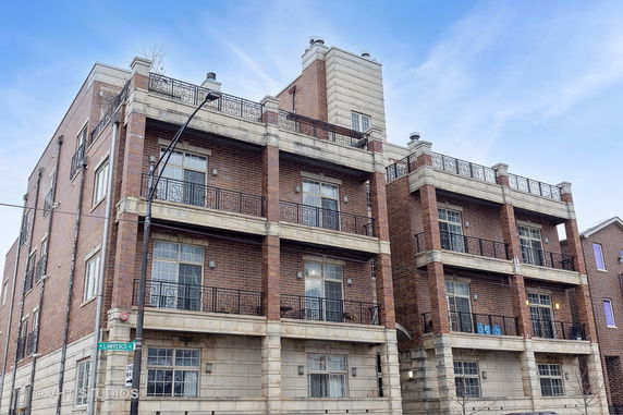 Front view of a multi-story brick building with balconies.