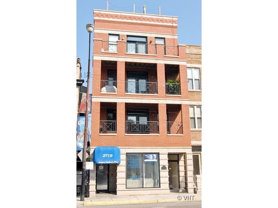 Front view of a multi-story brick building with balconies.