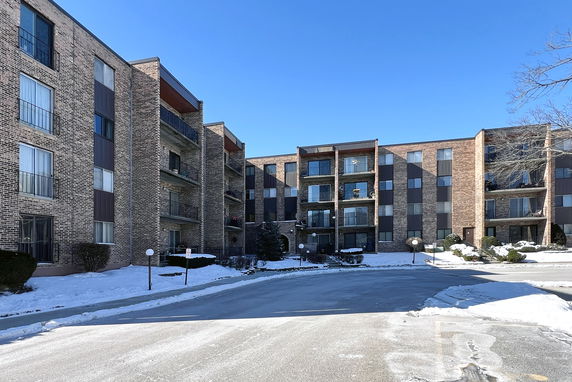 Front view of a multi-story residential building with brick facade and balconies.