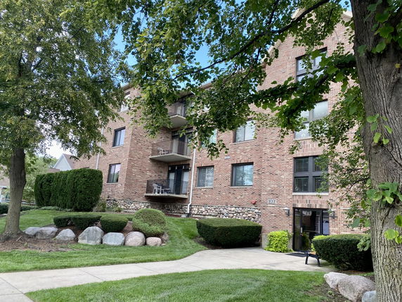 Front view of a multi-story brick building with balconies.