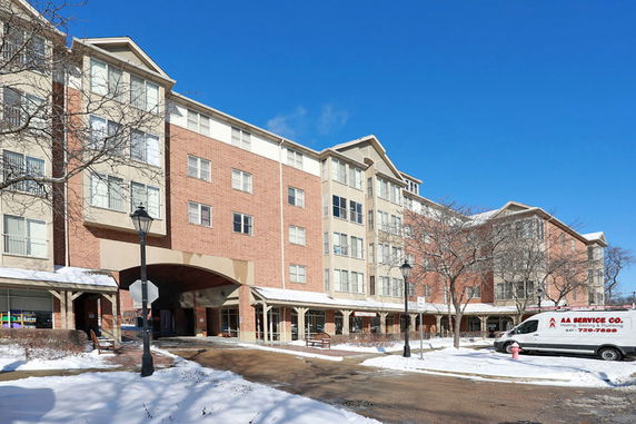 Front view of a multi-story residential building with brick and beige exterior.