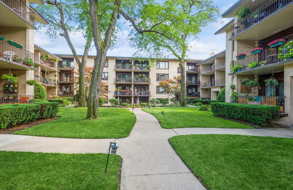View of apartment buildings with balconies and landscaped garden area.