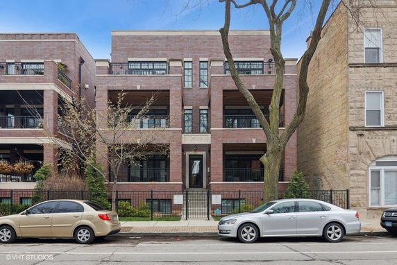Front view of a multi-story brick building with balconies.