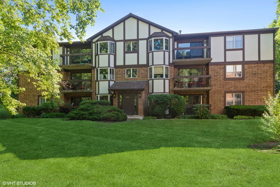 Front view of a three-story apartment building with a mix of brick and paneling exterior.