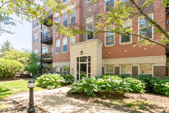 Front view of a multi-story brick apartment building with entrance.
