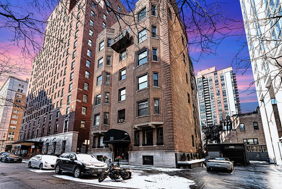 Front view of a multi-story brick building with an arched entrance.