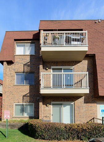 Front view of a multi-story brick building with balconies.