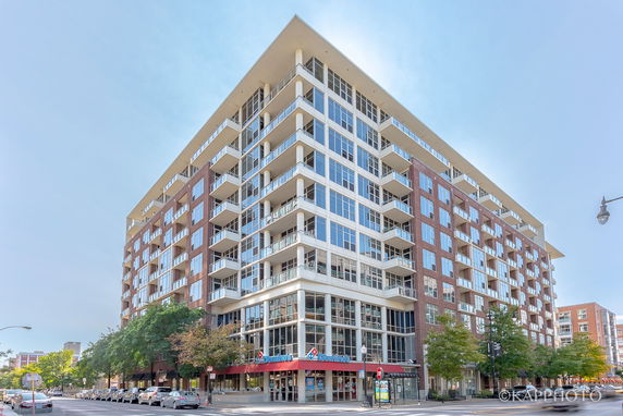 Front view of a multi-story mixed-use building with glass and brick facade.