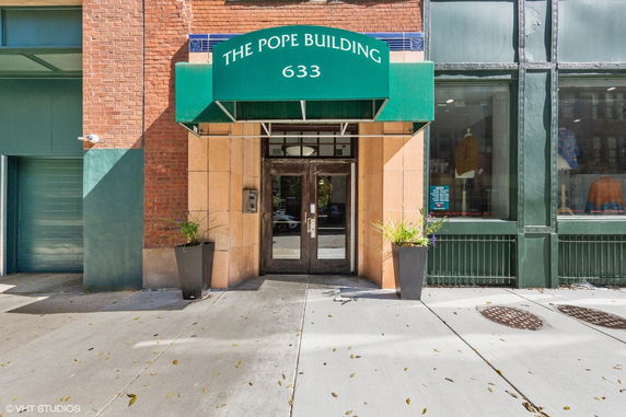 Front view of The Pope Building entrance with a green canopy displaying the building's name and street number.