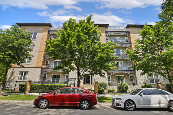 Front view of a multi-story apartment building with balconies.