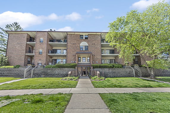 Front view of a multi-story apartment building with balconies.